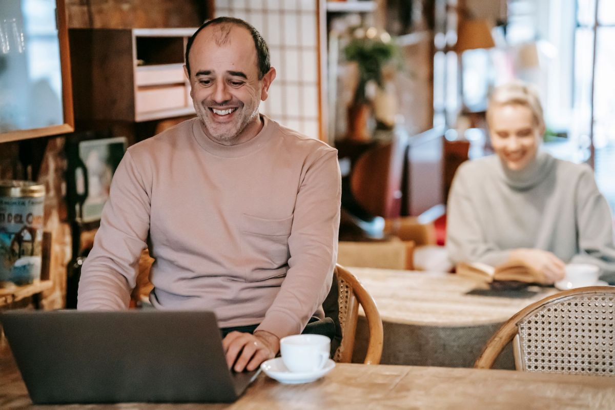 A man laughing at his laptop
