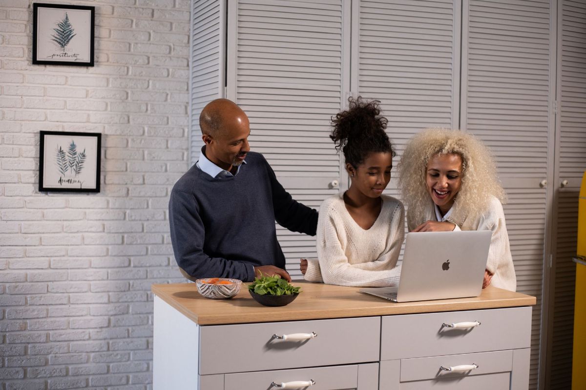 Parents and their teenage daughter at a laptop